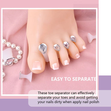 Close-up of a foot using crystal gem toe separators during a pedicure, with soft pink nail polish and decorative pearls