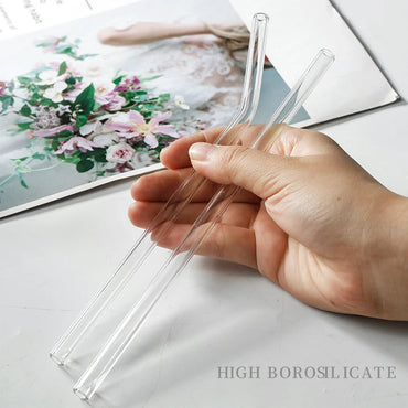 Hand holding two high borosilicate reusable glass straws – eco-friendly drinkware for cold beverages by BeTrendy