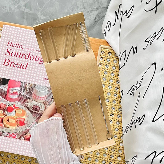 Set of reusable clear glass drinking straws with cleaning brush on wicker tray – eco-friendly kitchen essentials by BeTrendy