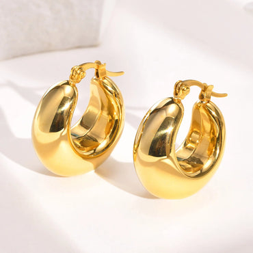 Pair of chunky C-shape hoop earrings in 18K gold-plated finish on white background