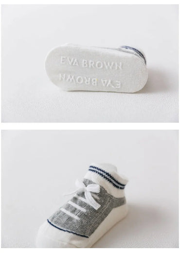 Gray 3D shoe-style baby sock with silicone anti-slip sole labeled 'EVA BROWN', shown from bottom and top angles for toddler safety and comfort