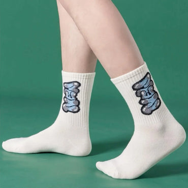 Model wearing white graffiti crew socks with blue urban lettering – men's streetwear style socks perfect for casual and athletic wear beTrendy