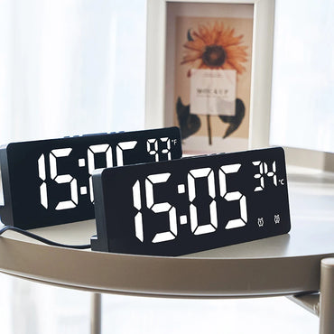 Two LED digital alarm clocks on a desk showing time and temperature in Celsius and Fahrenheit, ideal for home or office decor