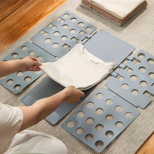 Person folding a shirt using a plastic clothes folding board for neat and fast laundry organization