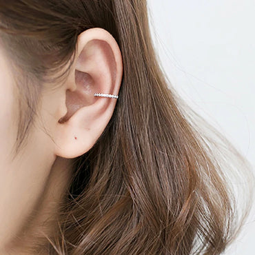 Side view of a woman wearing a silver clip-on earring with no piercing, minimalist and elegant design.