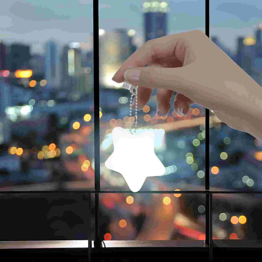Star-shaped purse light clipped to handbag on cafΓ© table, ideal for travel and night use