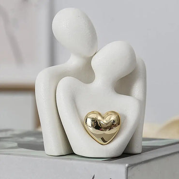 Modern white ceramic couple sculpture with gold heart symbolizing love, ideal for romantic home decor or anniversary gifts