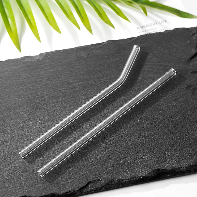 Reusable straight and bent clear glass straws on black slate background – eco-friendly minimalist drinkware by BeTrendy