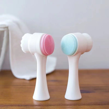 Pink and blue dual-sided silicone face cleansing brushes standing upright on wooden surface – non-electric exfoliating tools for gentle skincare by BeTrendy