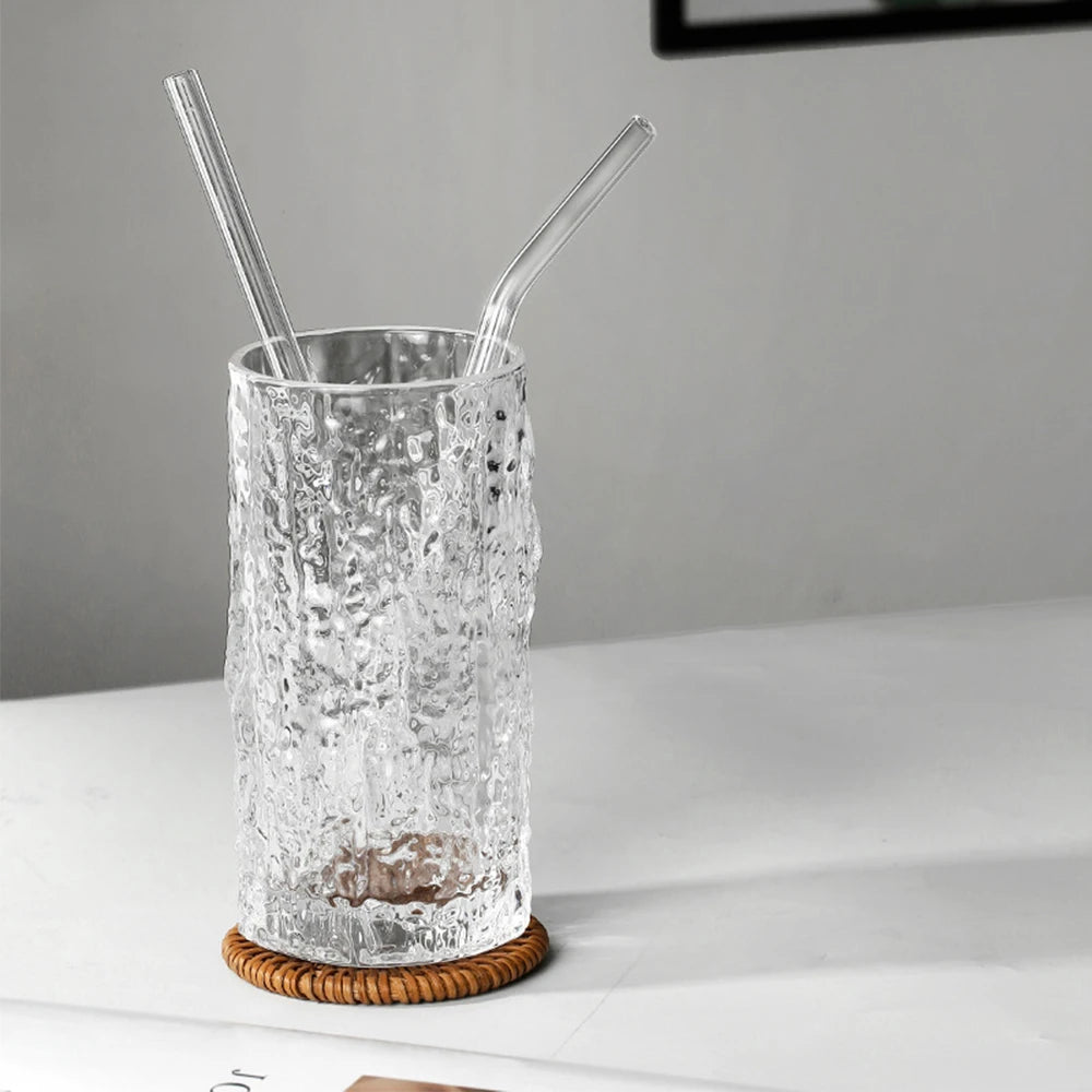 Two reusable glass straws in a textured tall glass on coaster – modern eco-friendly drinkware set by BeTrendy”