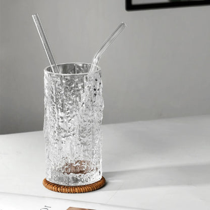 Two reusable glass straws in a textured tall glass on coaster – modern eco-friendly drinkware set by BeTrendy”