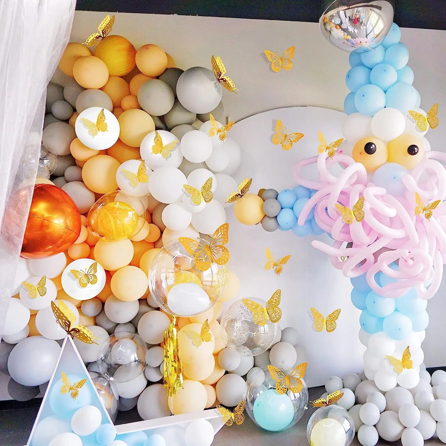 Colorful balloon party backdrop decorated with gold 3D butterfly wall stickers for a festive celebration BeTrendy