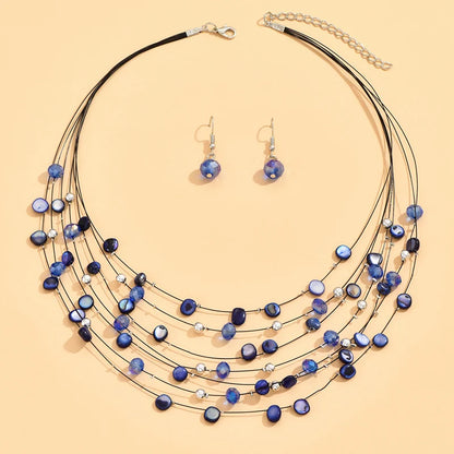 Elegant dark blue shell necklace and matching earrings in a layered boho design. Boho.  BeTrendy