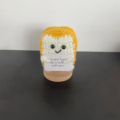 Handmade crochet toast plush doll with smiling face, holding a sign that says "Nice and toasty – Life is butter with you!