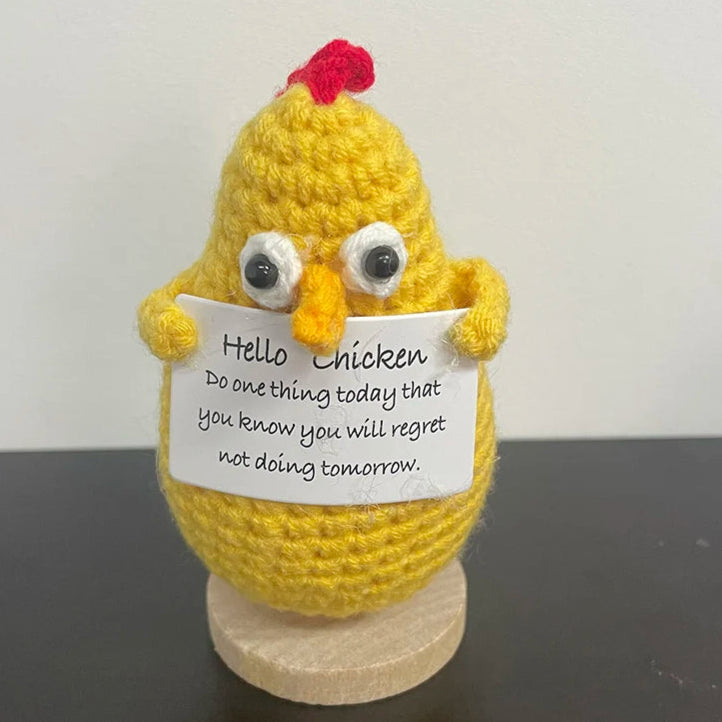 Handmade crochet chicken holding a sign that says 'Hello Chicken, do one thing today that you know you will regret not doing tomorrow' — funny motivational desk or shelf decor
