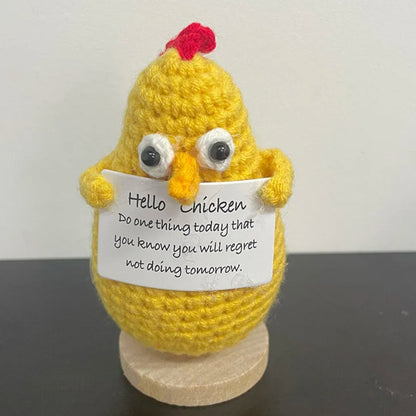 Handmade crochet chicken holding a sign that says 'Hello Chicken, do one thing today that you know you will regret not doing tomorrow' — funny motivational desk or shelf decor