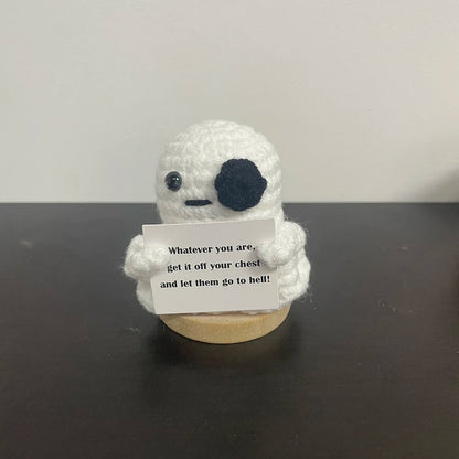 Crochet ghost plush with black eye patch holding sign that says 'Whatever you are, get it off your chest and let them go to hell!' — quirky desk decor gift