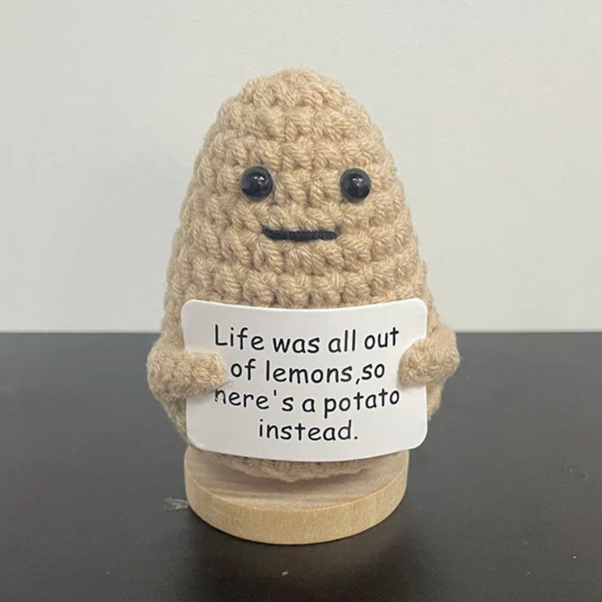 Handmade crochet potato holding sign that says 'Life was all out of lemons, so here's a potato instead' — cute and humorous motivational gift for desk or shelf