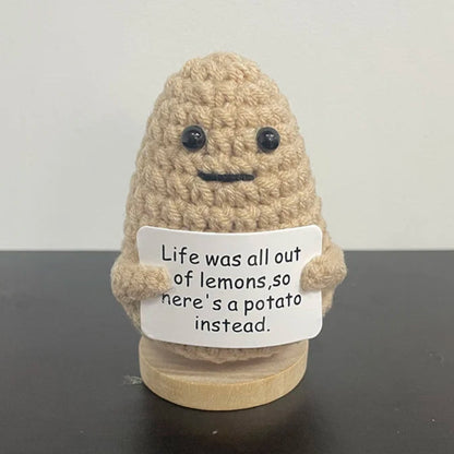 Handmade crochet potato holding sign that says 'Life was all out of lemons, so here's a potato instead' — cute and humorous motivational gift for desk or shelf