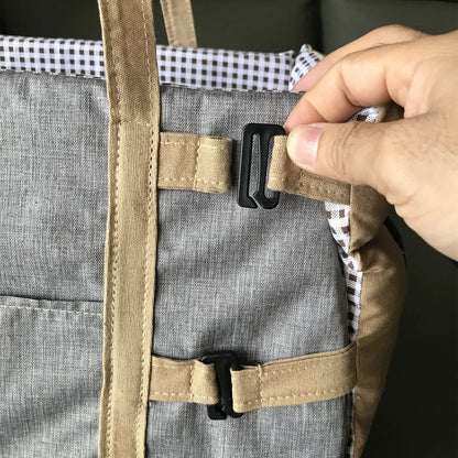 Close-up of safety buckle and adjustable strap on the dog car seat for secure attachment.
