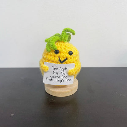 Yellow crochet pineapple plush with green top, smiling face, and a sign that says "Fine-Apple. It's fine. You're fine. Everything's fine.