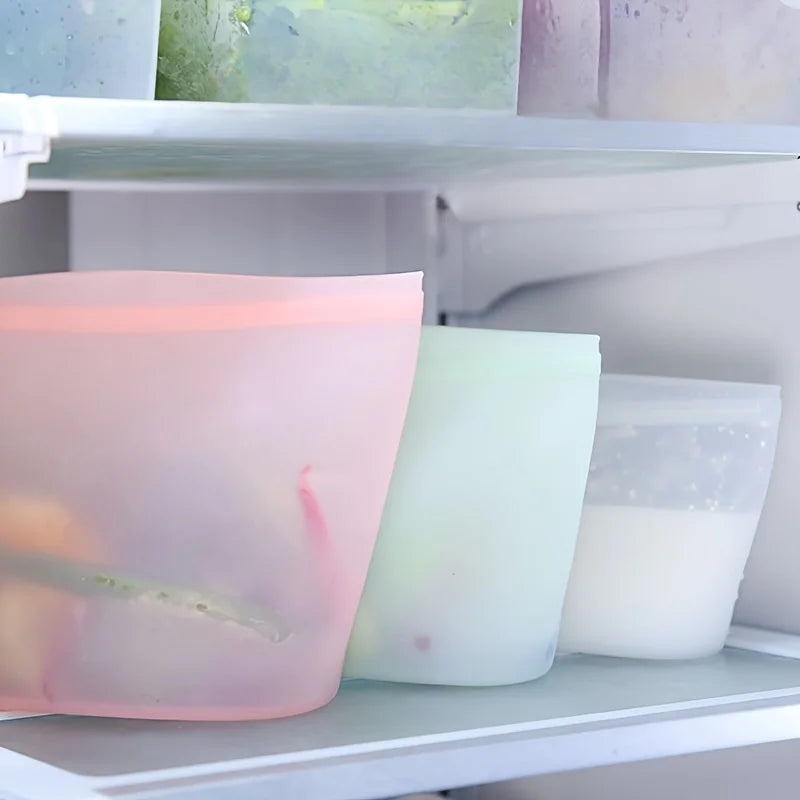 Reusable silicone food storage bags filled with vegetables and liquids, neatly stored inside a freezer compartment for safe, space-saving preservation