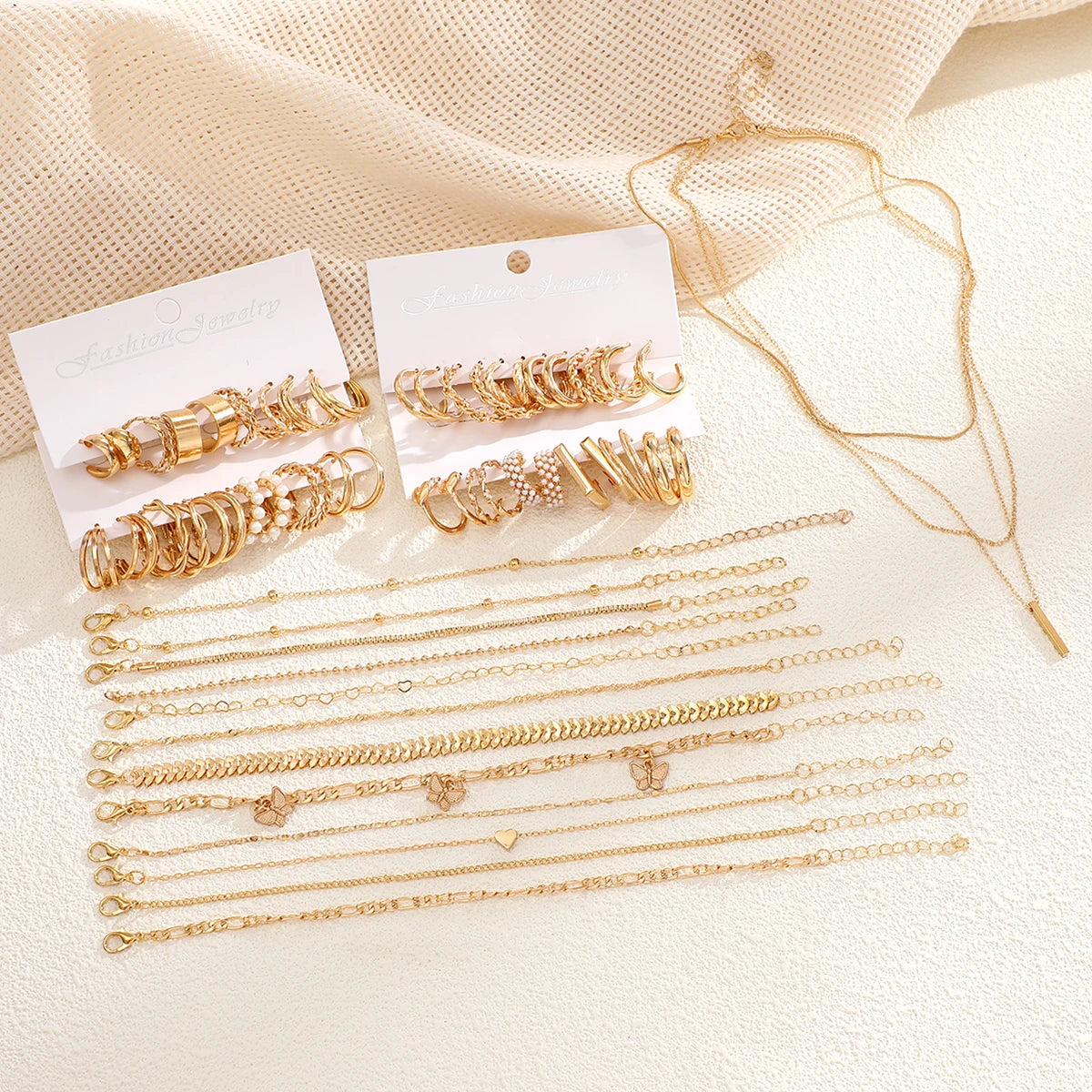 Flat lay of 37-piece gold boho jewelry set with layered necklaces, bracelets, and geometric hoop earrings  Boho BeTrendy