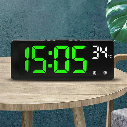 LED digital alarm clock with green numbers and Celsius temperature display, placed on a wooden table in a modern room setting BeTrendy