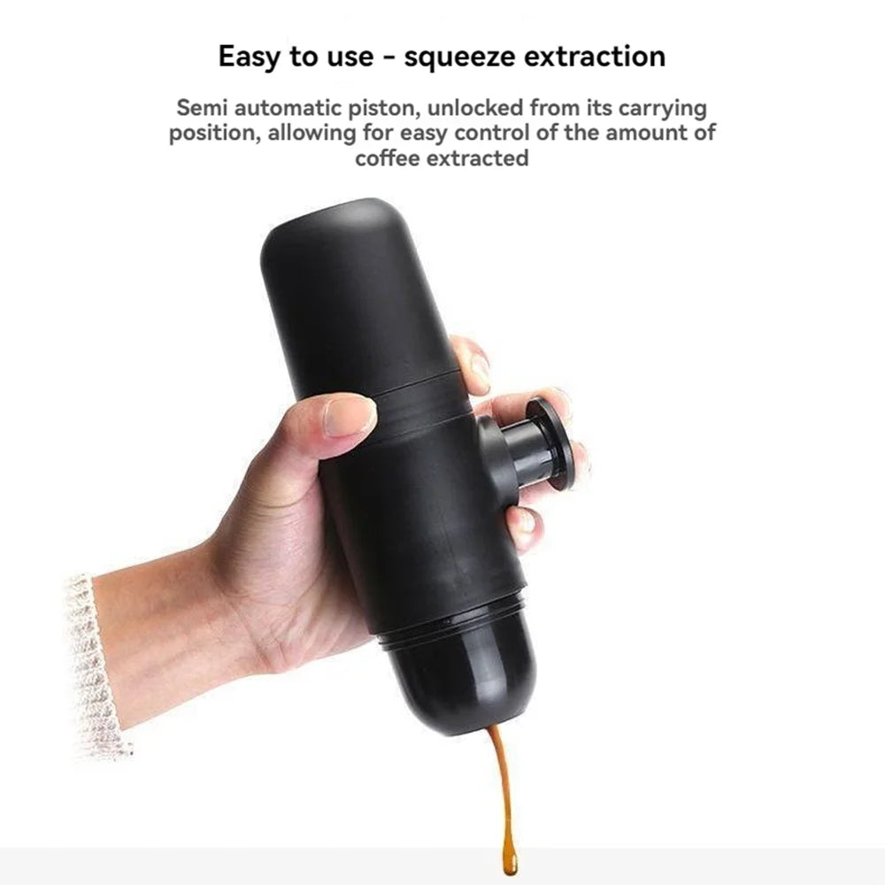 A hand using a black portable espresso coffee maker with a semi-automatic piston, extracting fresh coffee through squeeze pressure for easy and controlled brewing