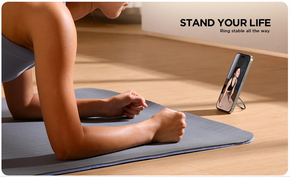 Woman on yoga mat watching a workout video on an iPhone propped up by the Joyroom magnetic phone ring holder in stand mode