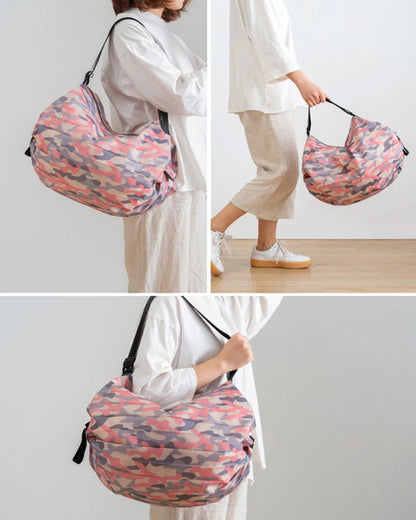 Woman showcasing a large pink camouflage Oxford shopping bag in three poses—over the shoulder, hand-carry, and crossbody style.  BeTrendy