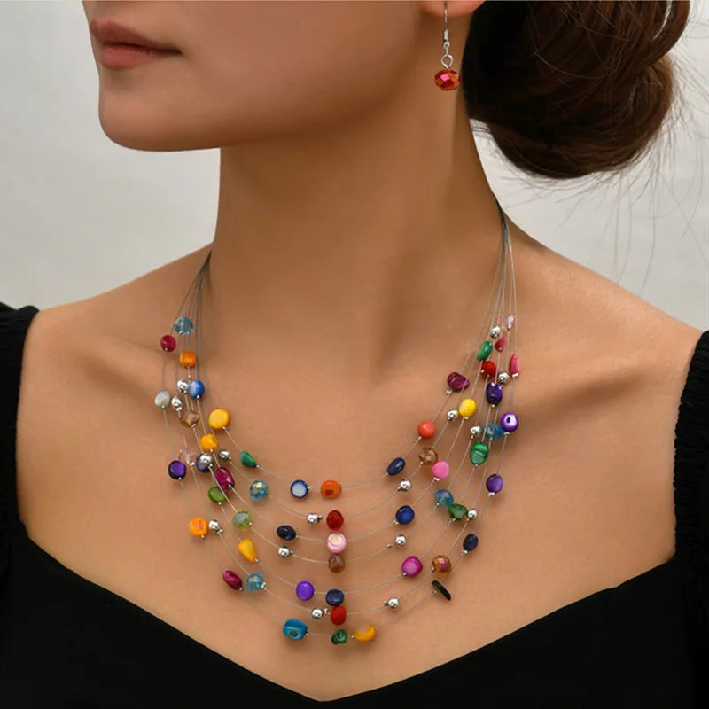 Bohemian layered shell necklace modeled with matching earrings in a close-up view.  BeTrendy