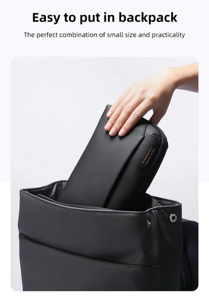 Compact Mark Ryden tech organizer pouch being placed in backpack – small size and practical design for easy travel use