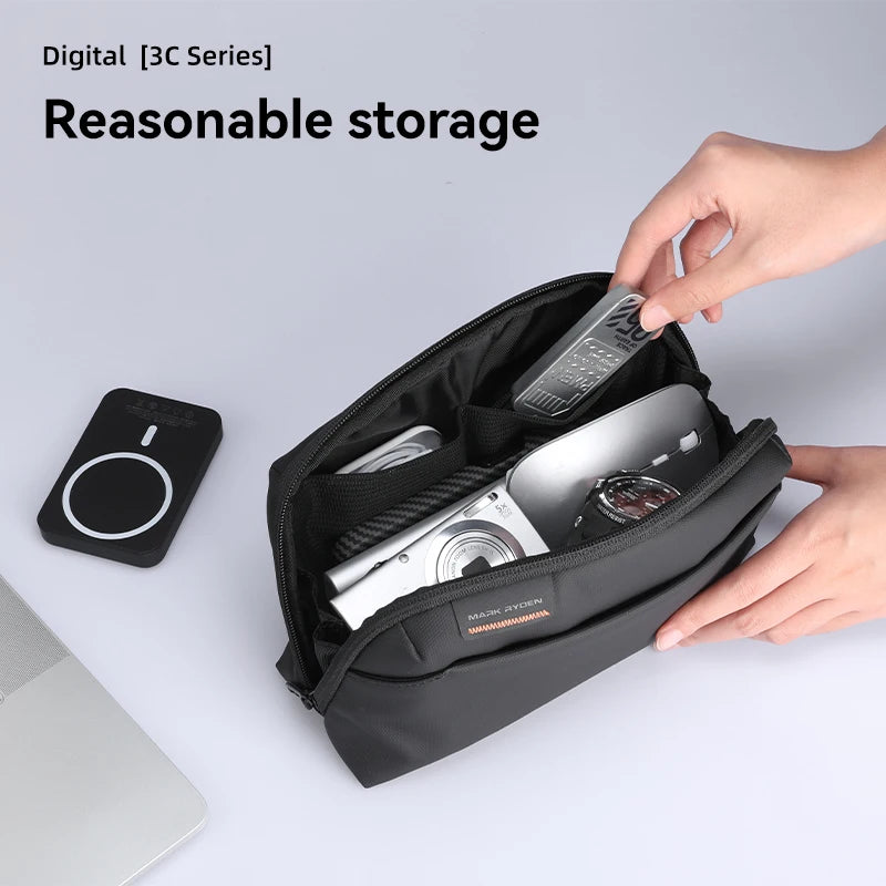 Hands organizing tech accessories in Mark Ryden compact storage pouch – neatly holds camera, power bank, remote, and watch.  BeTrendy