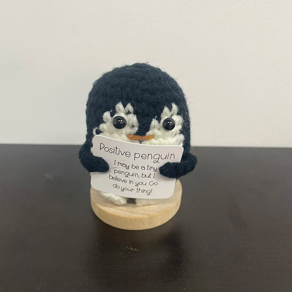 Handmade crochet penguin holding a sign that says "Positive penguin – I may be a tiny penguin, but I believe in you. Go do your thing!