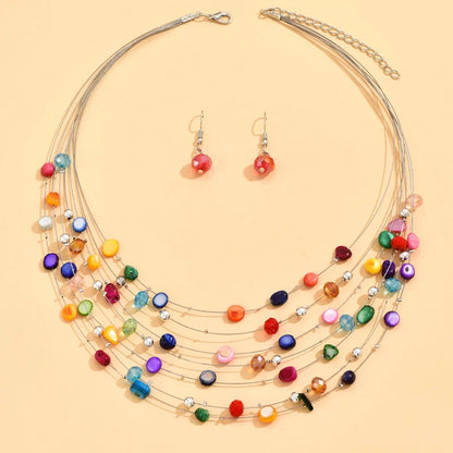Bohemian style colorful shell necklace with matching earrings displayed flat on beige background.  Boho. BeTrendy
