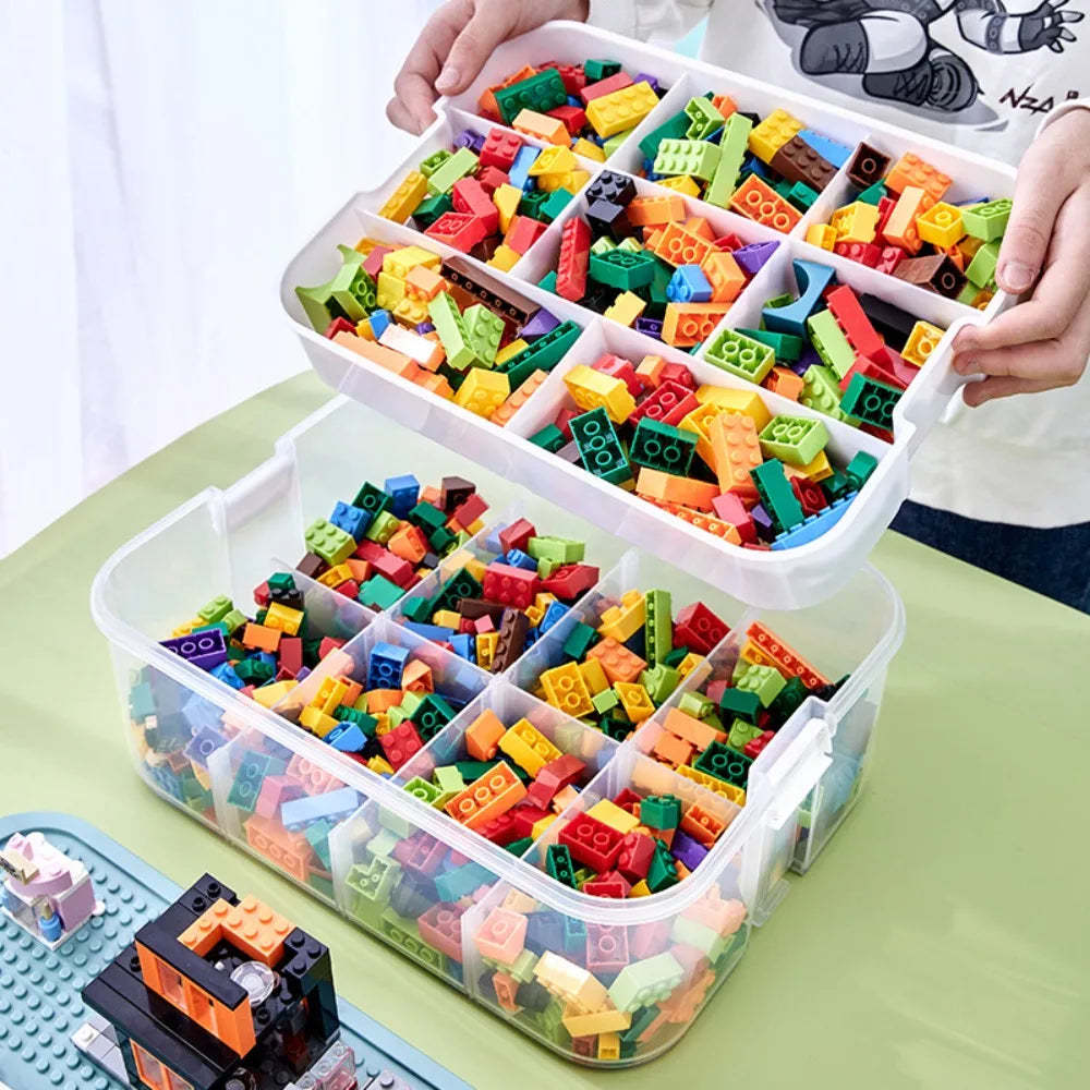 Hands lifting top divider tray from transparent Lego-compatible storage box filled with sorted colorful building blocks