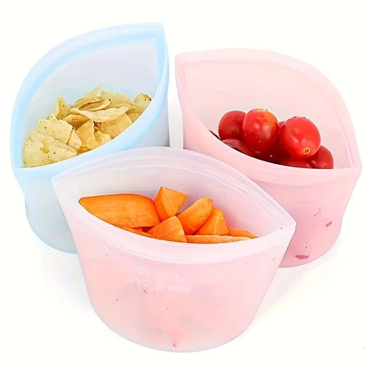 Three reusable silicone food storage bags filled with chips, cherry tomatoes, and sliced fruit—perfect for snacks, freezer use, or meal prep
