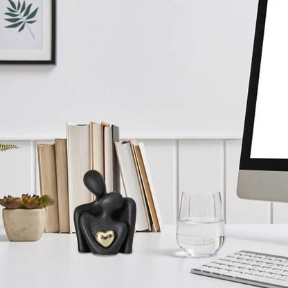 Black ceramic couple figurine with gold heart on modern office desk, romantic home or workspace decor