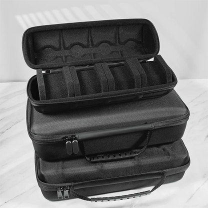 Stack of black zippered watch storage cases with foam compartments and carrying handles on a marble surface