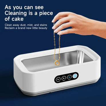 Hand placing gold necklace into ultrasonic cleaning machine to remove dust, mist, and stains for a like-new shine